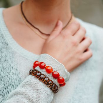 Model draagt Leopard (luipaard armband) bij een mintgroene trui, gecombineerd met Grenadine bonbon
