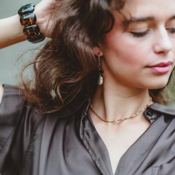 Squared bronze necklace gedragen bij een bruine satijnen blouse, van dichtbij, gecombineerd met Pink&Burgundy wires